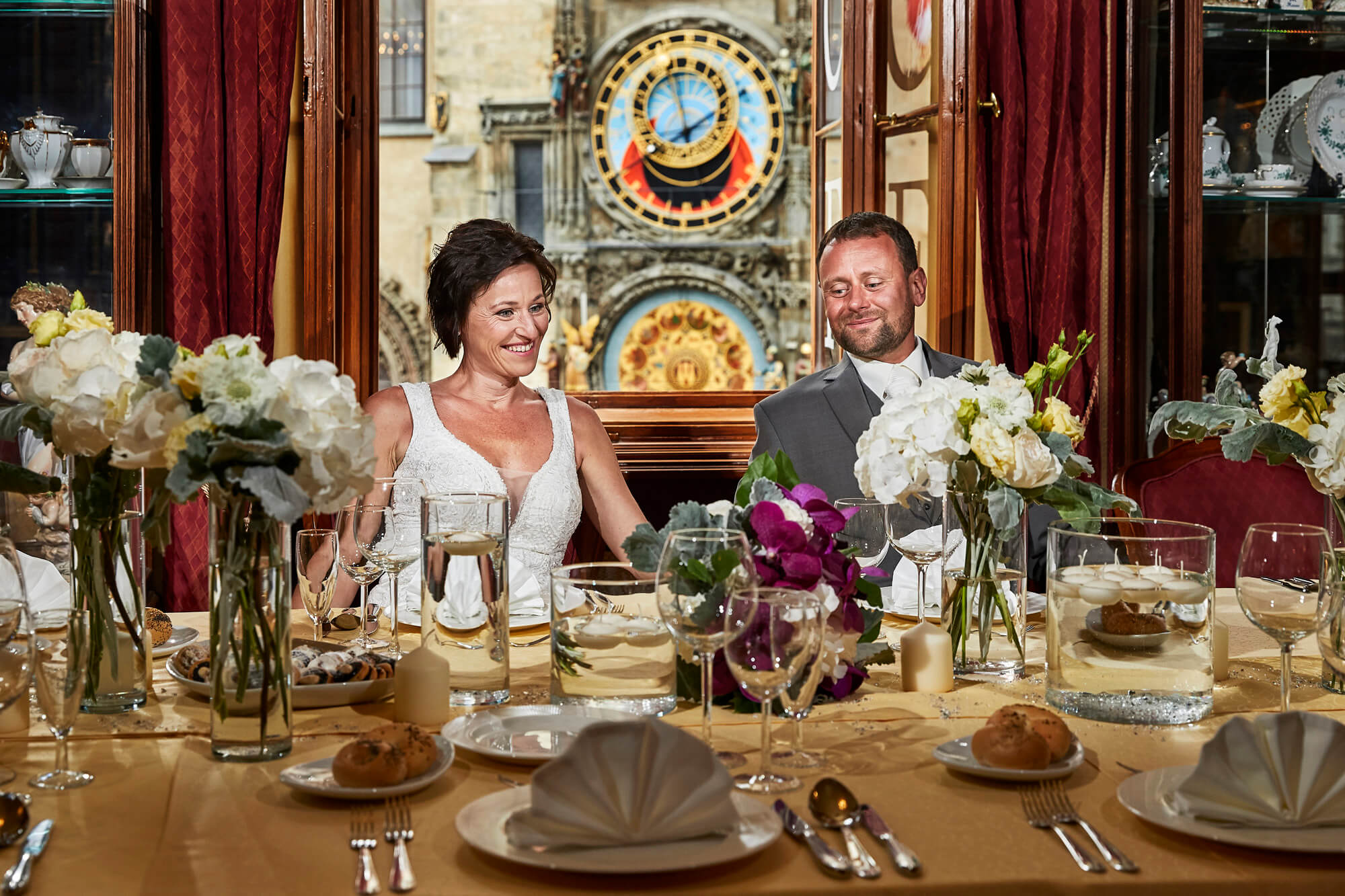 Kavárna Café Mozart, novomanželé u stolu, v pozadí Staroměstský orloj