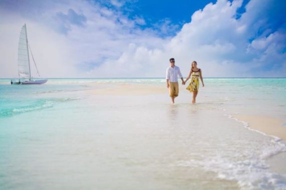 Dovolená snů s.r.o. snoubenci na pláži s plachetnicí