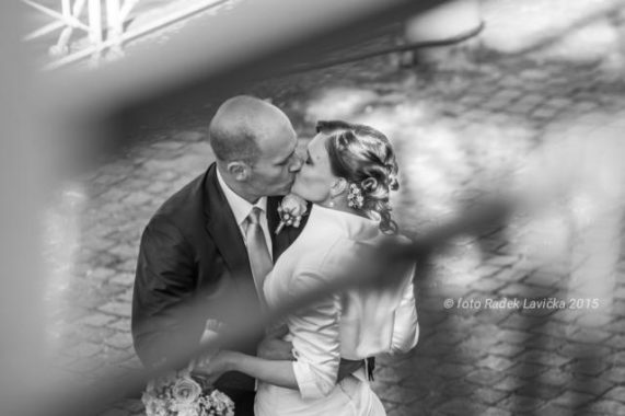 Svatební fotograf Radek Lavička polibek snoubenců za zábradíim