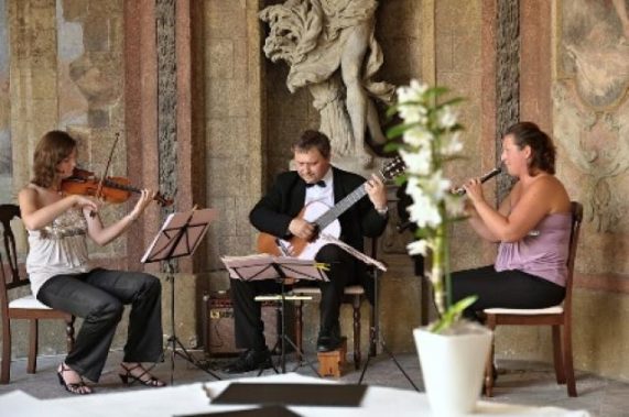 musica di praga hrají v sále s kamennou sochou v pozadí