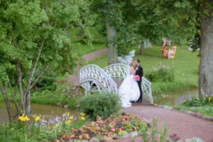 Svatební zamilovaný pár na mostku uprostřed parku v zeleni