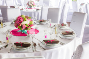 Elegantní svatební tabule s kyticí a bílými potahy na židlích