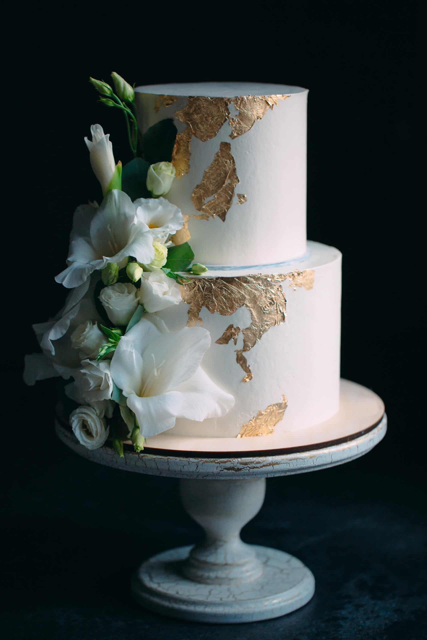 Dvoupatrový svatební dort s květinami na stojanu