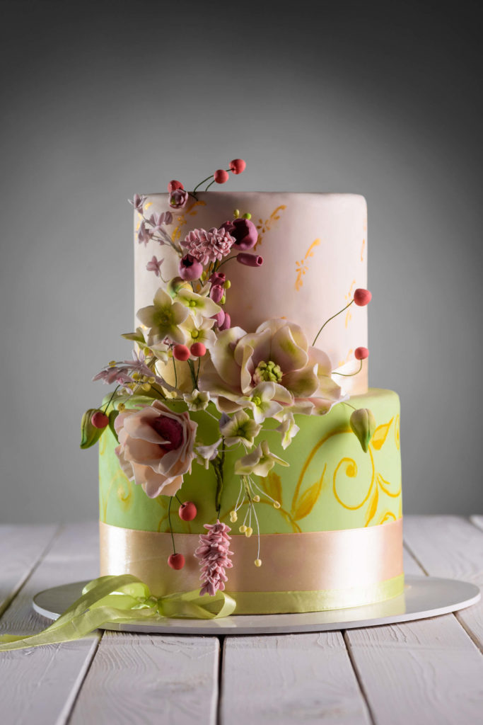 Krásně zdobený dvoupatrový svatební dort v zelenozlatém hávu