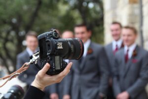 Svatební fotograf fotí muže na svatbě